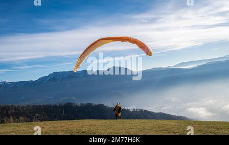 Homme sur une pente herbeuse préparer le planeur pour le parapente de Vetriolo terme, province de trente - Trentin Haut-Adige - école de parapente - Italie Banque D'Images