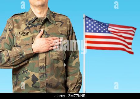 Un soldat américain faisant allégeance et le drapeau de son pays en arrière-plan Banque D'Images