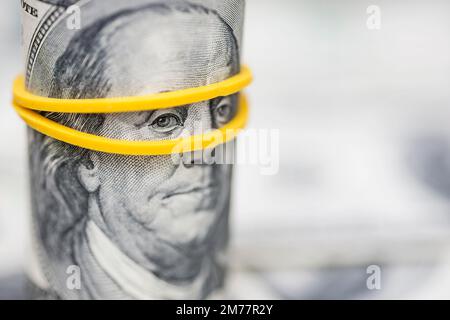 Rouleau de billets de 100 dollars, avec l'accent sur les yeux de Franklins avec rubberband Banque D'Images