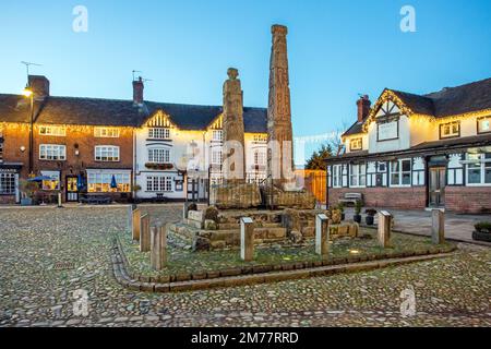 L'ancienne place du marché pavée illuminée dans la ville de Sandbach avec les croix saxonnes et deux vieilles auberges de coaching la nuit Banque D'Images