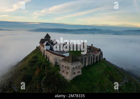 Vue aérienne sur le château de Sumeg avec un lever de soleil brumeux à l'arrière-plan. Banque D'Images