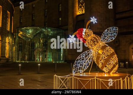 Décoration de rue de Noël sculpture illuminée d'une abeille, symbole de Manchester, Royaume-Uni. Banque D'Images