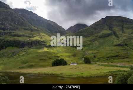 Petite maison blanche au pied des trois Sœurs à Glencoe, Highlands, Écosse, Royaume-Uni. Banque D'Images