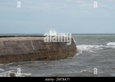 Vagues éclaboussant au-dessus de la mondialement célèbre Cobb à Lyme Regis Dorset Angleterre qui présente dans le roman de Jane Austen persuasion Banque D'Images