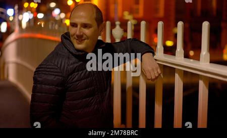 Jeune homme debout sur le pont Ha Penny à Dublin - photographie de voyage Banque D'Images