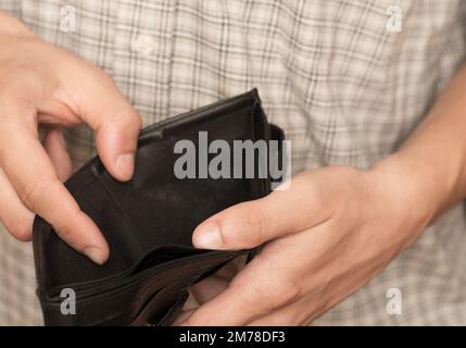 Gros plan des mains d'homme tenant et vide le portefeuille Banque D'Images