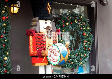 Arrière-plan des vacances de Noël avec jouet de casse-noisette et fenêtre de magasin décorée. Acheter des cadeaux et des souvenirs pour les fêtes d'hiver. Marché de Noël. Banque D'Images