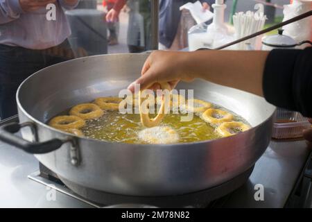 Les Picarones sont des bonbons frits en forme d'anneau faits avec de la pâte de farine de blé mélangée à de la courge, et parfois de la patate douce, baignée dans le miel de chancaca aromatisé. Banque D'Images