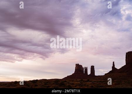 lever de soleil sur silhouettes de buttes dans la vallée du monument Banque D'Images