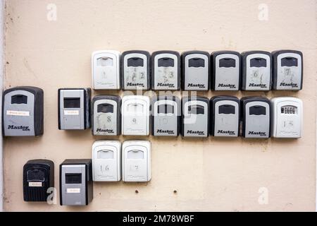 Petits coffres-forts contenant les clés d'un bâtiment fixés par des cadenas combinés fixés à un mur Banque D'Images