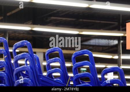 Une photo à angle bas des poignées en plastique bleues des chariots dans un magasin Banque D'Images