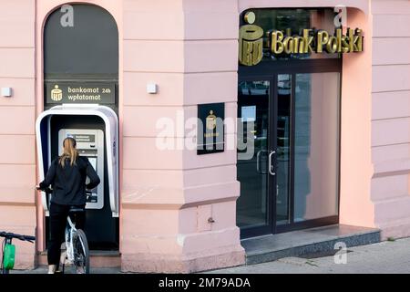 BYDGOSZCZ, POLOGNE - 10 AOÛT 2022 : bureau du PKO de Bank Polski avec une jeune femme qui retire de l'argent de l'ATM Banque D'Images