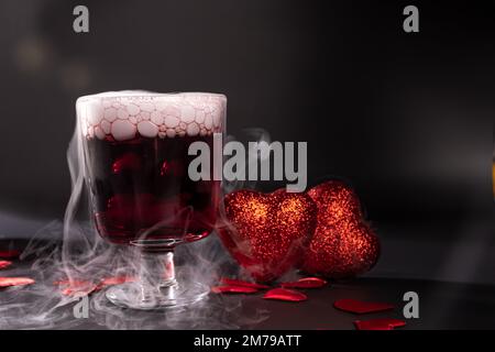 Cocktail de Saint-Valentin avec glace sèche sur fond sombre Banque D'Images