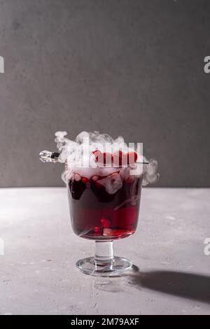 Cocktail de Saint-Valentin avec glace sèche sur fond sombre Banque D'Images