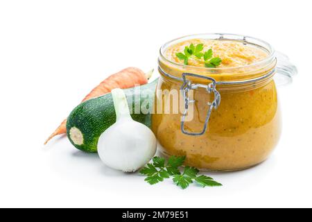 Purée de courgettes dans un pot en verre isolé sur blanc Banque D'Images