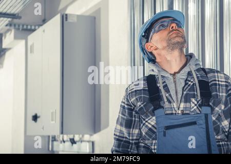 Technicien professionnel regardant les conduits HVAC installés sous le plafond dans le bâtiment commercial. Système de chauffage, climatisation et ventilation Banque D'Images