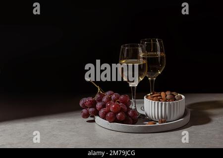 Verres de champagne, raisins et noix sur la table Banque D'Images