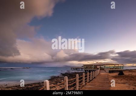 Exposition longue au lever du soleil sur la côte près de Corralejo, magnifique baie avec jetée le matin, Parque Natural de Corralejo, Fuerteventura, Canary Banque D'Images