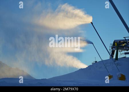 Canons à neige dans les montagnes d'hiver. Pistolet à neige pulvérisant des cristaux de glace artificiels. Machine faisant de la neige Banque D'Images