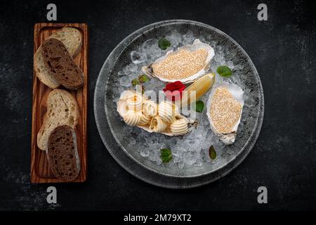 Pike caviar sur une assiette avec de la glace, du citron et du beurre Banque D'Images