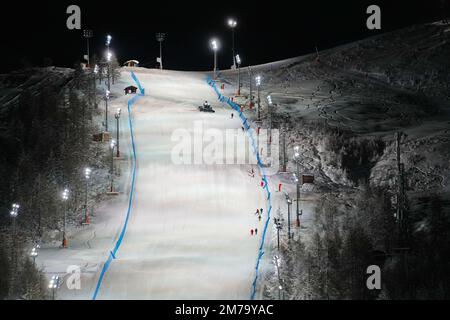 Vue panoramique nocturne sur une piste de ski enneigée éclairée. Service de ski de nuit à la station de montagne d'hiver de Sestriere Banque D'Images