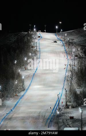 Vue panoramique nocturne sur une piste de ski enneigée éclairée. Service de ski de nuit à la station de montagne d'hiver de Sestriere Banque D'Images