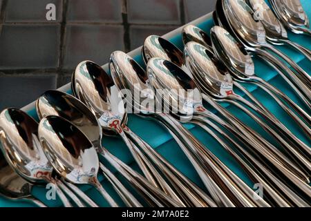 Groupe de cuillères en métal d'acier dans un plateau avec tapis vert, une station côté restaurant Banque D'Images
