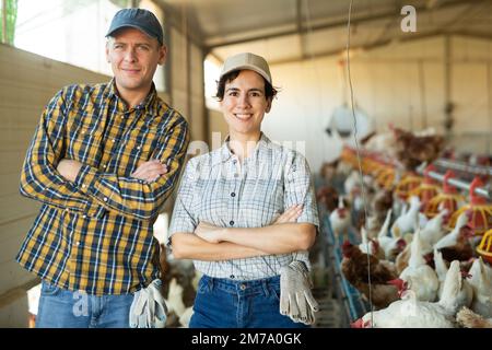 Couple réussi d'agriculteurs qui se posent ensemble dans le poulailler Banque D'Images
