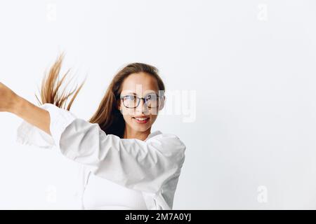 Portrait de femme avec une peau bronzée et de longs cheveux naturels coulant posant sur un fond blanc portant des lunettes Banque D'Images