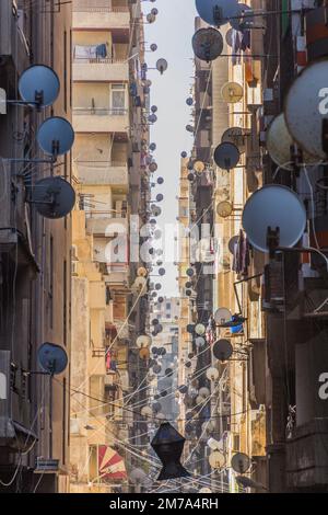 Ruelle étroite avec des plats satellites à Alexandrie, Egypte Banque D'Images