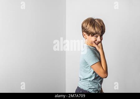 Un pré-adolescent Tween garçon faisant un drôle de visage rétréci vers le haut avec un fond blanc et un espace de copie Banque D'Images