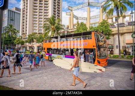 Honolulu, Hawaï - 29 décembre 2022 : le tramway de Waikiki qui prend les touristes sur l'avenue Kalakaua. Banque D'Images