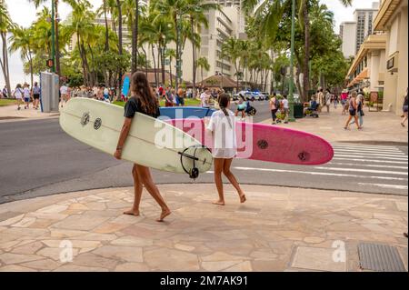 Honolulu, Hawaï - 29 décembre 2022: Famille transportant des planches de surf à Waikiki Beach. Banque D'Images