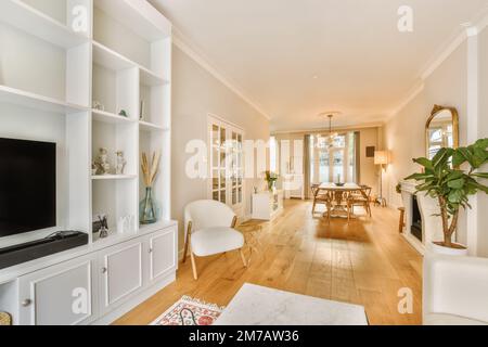 un salon avec parquet et mobilier blanc au centre de la chambre est une grande télévision à écran plat Banque D'Images