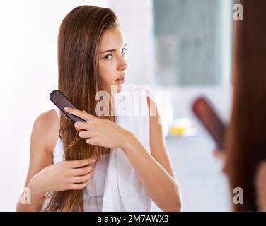Un look élégant et brillant. une jeune femme attrayante utilisant un fer à repasser plat. Banque D'Images