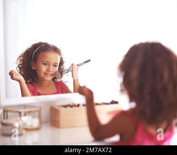 Petite Fille Applique De La Poudre Avec Un Pinceau De Maquillage. Mettre Du  Fard À Joues. Un Enfant Joyeux A Des Tresses De Cheveux. Cosmétiques  Naturels Pour Enfants Banque D'Images et Photos