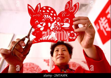 HANDAN, CHINE - le 9 JANVIER 2023 - Feng Shiping, artiste de la coupe de papier folklorique, crée des coupes de papier pour l'année du lapin dans la ville de Handan, dans le Hebei en Chine du Nord Banque D'Images