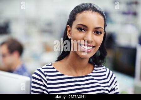 Shes le chef de son équipe de conception. Portrait d'une jeune femme attrayante avec ses collègues en arrière-plan. Banque D'Images