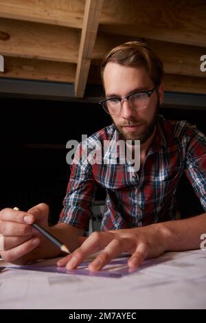 Perfectionner les plans avant le début de la construction. un jeune architecte masculin élabore des plans de construction. Banque D'Images