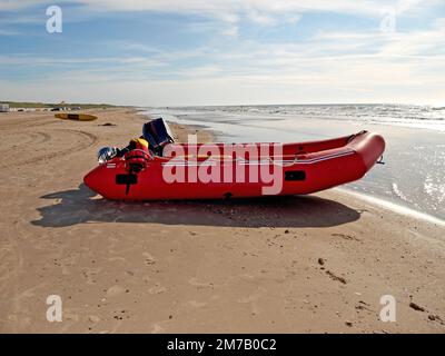 L'aventure vous appelle... Une dingy rouge sur la plage le jour de l'été. Banque D'Images