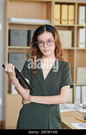Portrait d'un jeune architecte avec une tablette au bureau et une tablette à la main Banque D'Images