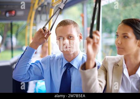 Elle m'aide à rester en compagnie sur les transports. Deux jeunes collègues voyageant dans le bus et se tenant sur les sangles. Banque D'Images