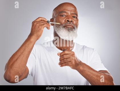 Homme âgé, sérum pour le visage et soins de la peau avec dermatologie et cosmétiques pour une peau propre, lumineuse et fraîche. Portrait d'un homme noir avec une pipette pour Banque D'Images