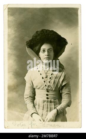 Carte postale originale et claire d'un portrait de studio d'une jeune femme de l'époque édouardienne forte volonté sérieuse / sincère, appelée Katie, qui a écrit « votes pour les femmes » sous son image sur une carte postale. Peut-être était-elle une suffragette ou une suffragante ou juste un sympathisant de la cause. Elle porte un grand chapeau attaché avec un foulard. Elle a vécu à Londres. Du studio de Laffitte 184 Western Road, Brighton, Sussex, Angleterre, posté de South Tottenham, Londres, Royaume-Uni Daté / posté le 13th février 1911. Banque D'Images