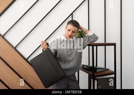 Femme d'affaires au bureau avec une mallette en cuir pour les documents entre ses mains Banque D'Images