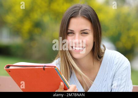 Un étudiant heureux regarde la caméra dans un parc Banque D'Images