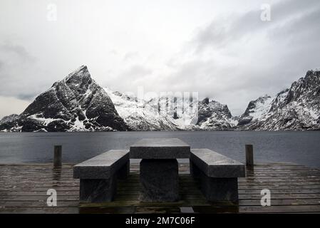 Table en pierre et banc pour prendre un frein avant un paysage merveilleux dans le village de Sakrisoya pendant la saison d'hiver, péninsule de Lofoten, nord de la Norvège. Banque D'Images