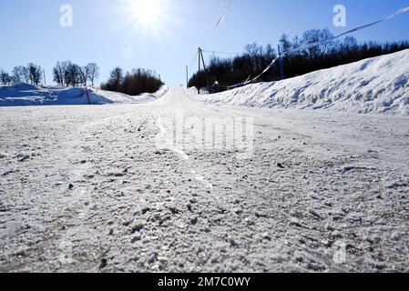 Une route cahoteuse emptyness recouverte de neige près de Kirkenes, dans l'extrême nord de la Norvège, à Neiden. Banque D'Images
