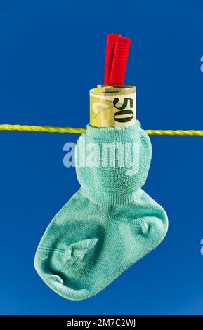 Chaussettes de bébé avec francs suisses sur corde à linge, Suisse Banque D'Images