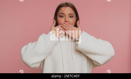 Je ne dirai personne. Femme sincère effrayée fermant la bouche avec la main, regardant intimidée peur à la caméra, gestes non, refusant de dire un terrible secret, vérité incroyable. Peur jeune fille Banque D'Images